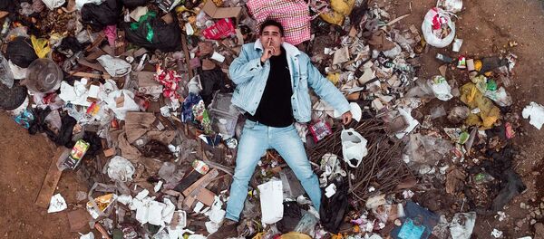 Un hombre entre la basura de plástico Un hombre entre la basura de plástico - Sputnik Mundo