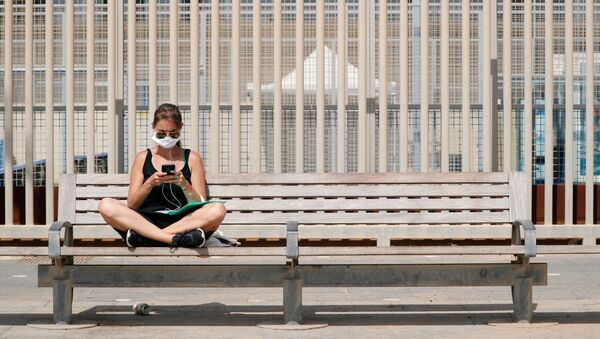 Una joven con una mascarilla en España - Sputnik Mundo