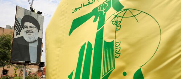 La bandera de Hizbulá  y el retrato de su líder, Hasán Nasralá - Sputnik Mundo