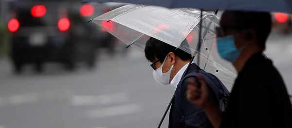 Dos hombres con mascarillas durante una nueva propagación del coronavirus en Tokio, Japón - Sputnik Mundo