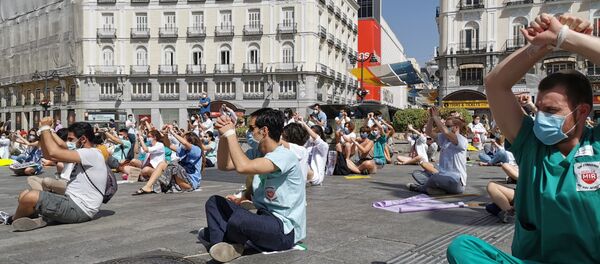 Residentes manifestándose sentados y atados en la Puerta del Sol (Madrid) - Sputnik Mundo