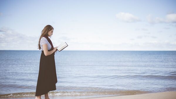 Una mujer leyendo un libro - Sputnik Mundo