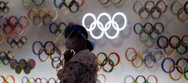 Una chica con mascarilla cerca de logo de Juegos Olímpicos (JJOO) en Tokio durante el brote de coronavirus en Japón - Sputnik Mundo