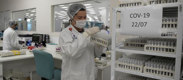 Un empleado encargado de los tests de COVID-19 en un laboratorio en Brasil - Sputnik Mundo