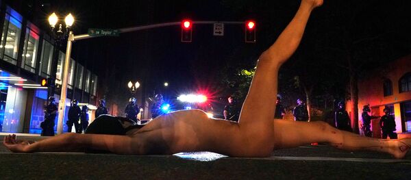 Una mujer se desnuda durante una protesta contra la desigualdad racial en Portland, Oregon, EEUU - Sputnik Mundo