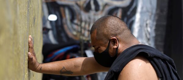 Un hombre con mascarilla rezando a la Santa Muerte en Ciudad de México Un hombre con mascarilla rezando a la Santa Muerte en Ciudad de México - Sputnik Mundo