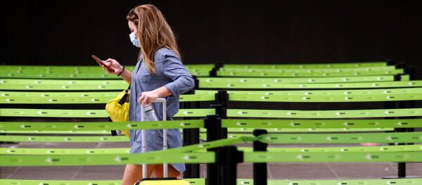 Una mujer en mascarilla en el aeropuerto El Prat de Barcelona, España Una mujer en mascarilla en el aeropuerto El Prat de Barcelona, España - Sputnik Mundo