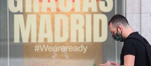 Un hombre pasa junto a una tienda que tiene un mensaje que dice Gracias Madrid. Foto de archivo.  - Sputnik Mundo