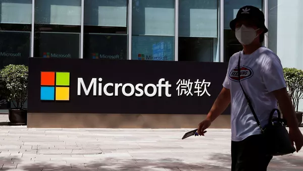 Una persona pasa junto a un logo de Microsoft en la oficina de Microsoft en Pekín
