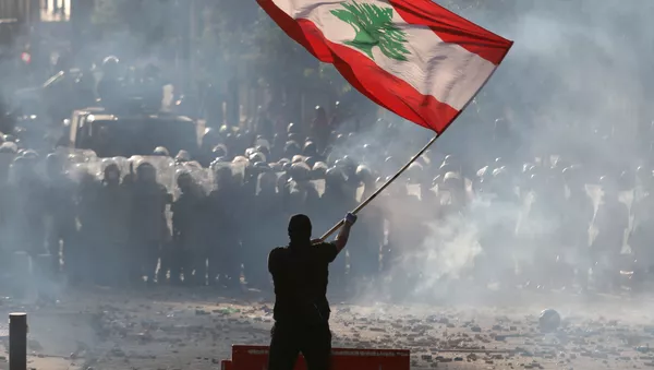 Un manifestante sostiene la bandera del Líbano durante las multitudinarias protestas contra la gestión del Gobierno tras la explosión en el puerto de Beirut, el 8 de agosto de 2020