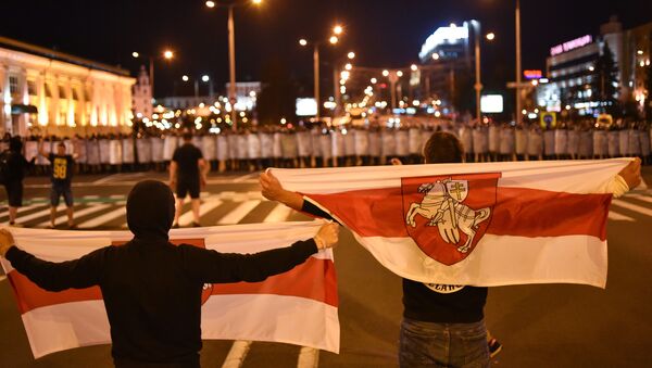 Manifestantes se paran en frente de la Policía durante una protesta en Minsk - Sputnik Mundo