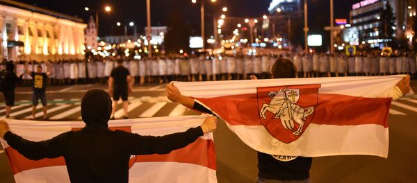 Manifestantes se paran en frente de la Policía durante una protesta en Minsk - Sputnik Mundo