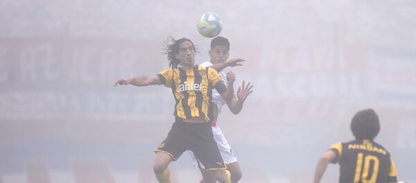 Futbolistas de Peñarol y Nacional disputan el balón en el clásico del fútbol uruguayo en medio de una intensa niebla - Sputnik Mundo