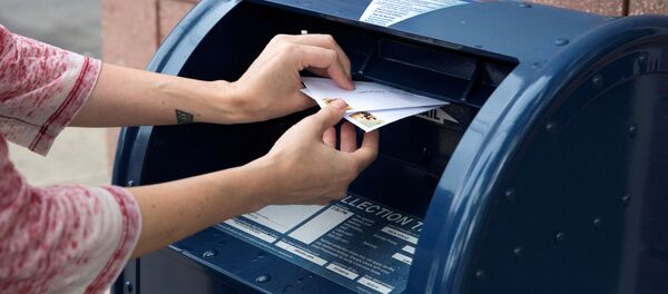 Un individuo coloca sobres en un buzón Un individuo coloca sobres en un buzón - Sputnik Mundo