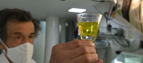 Farmacéutico boliviano con un vaso de dióxido de cloro - Sputnik Mundo