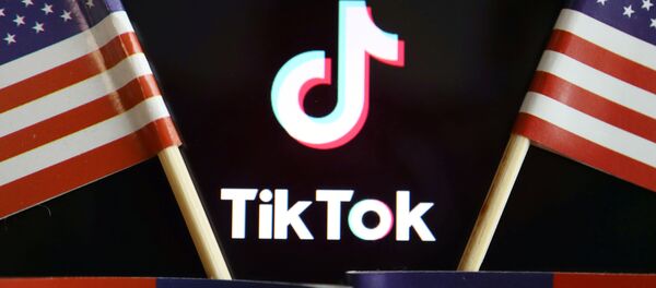 El logo de TikTok junto a banderas estadounidenses - Sputnik Mundo