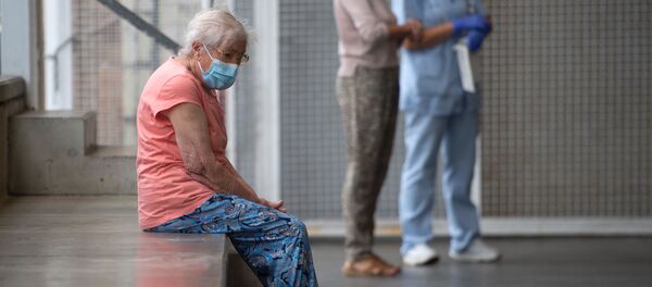 Una anciana espera ser examinada en un centro médico - Sputnik Mundo