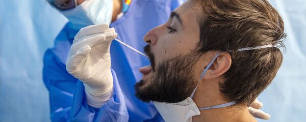 Un trabajador de la salud toma una muestra para una prueba de PCR para el COVID-19 en un centro médico en Madrid. 17 de agosto - Sputnik Mundo