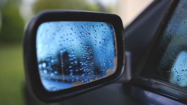 Gotas de agua en el retrovisor de un auto - Sputnik Mundo