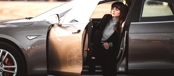 Una mujer en el interior de un vehículo de la marca Tesla - Sputnik Mundo