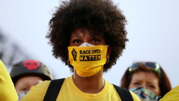 Una chica con un tapabocas donde dice 'Black lives matter' Una chica con un tapabocas donde dice 'Black lives matter' - Sputnik Mundo