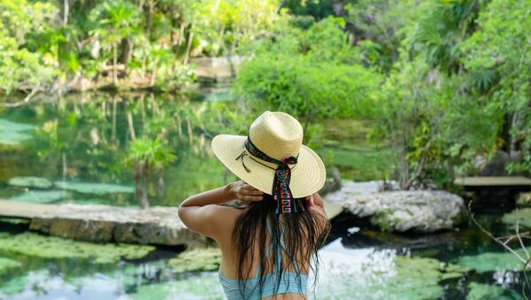 Una mujer disfruta de la vista en un cenote, México  - Sputnik Mundo