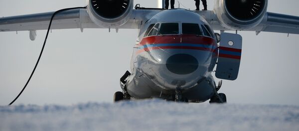 Dos técnicos reponen combustible en el avión An-74 en una isla que forma parte de la Tierra del Norte - Sputnik Mundo