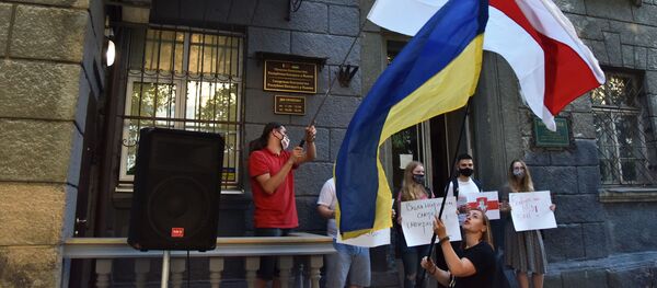 Una bandera de Ucrania y una bandera de la oposición bielorrusa en una manifestación en Kiev - Sputnik Mundo
