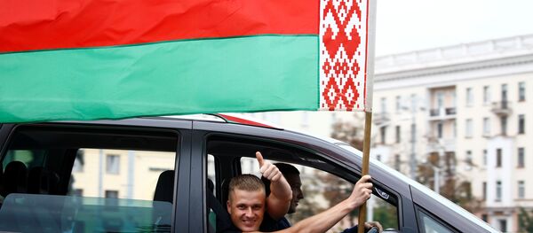 Un hombre ondea la bandera nacional bielorrusa desde la ventana de un automóvil en Minsk, Bielorrusia - Sputnik Mundo