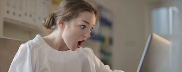 Una mujer pasmada frente al ordenador, referencial - Sputnik Mundo