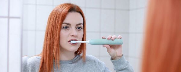 Una chica cepillándose los dientes - Sputnik Mundo