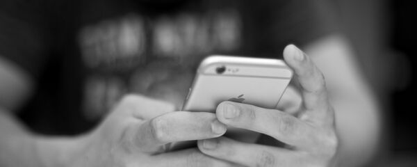 Una persona sostiene un móvil en las manos - Sputnik Mundo