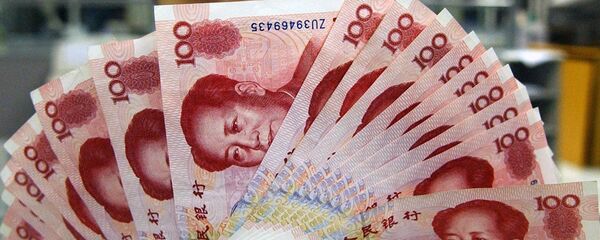 Una mujer sostiene yuanes - Sputnik Mundo