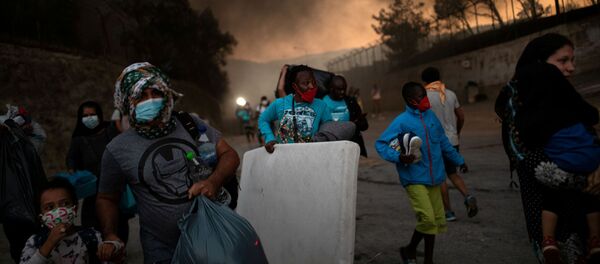 Refugiados se escapan del campo de refugiados de Moria en llamas Refugiados se escapan del campo de refugiados de Moria en llamas - Sputnik Mundo