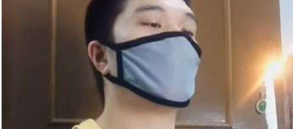 Un hombre con mascarilla y vela - Sputnik Mundo