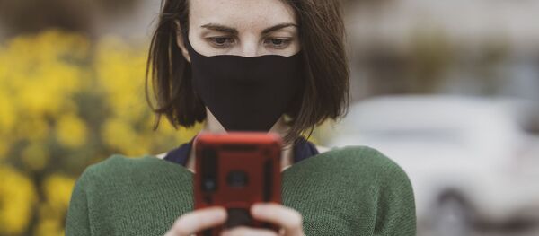 Mujer con mascarilla usando el celular - Sputnik Mundo