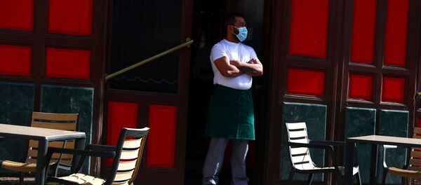 Un camarero con mascarilla esperando clientes en una terraza de Madrid - Sputnik Mundo