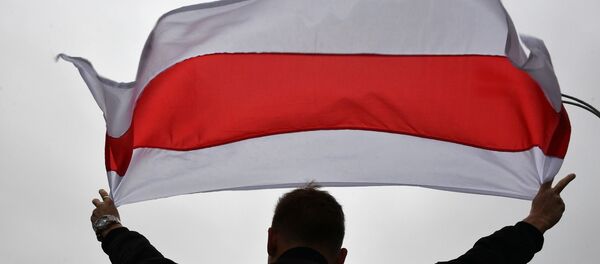 Un manifestande con la bandera de Bielorrusia - Sputnik Mundo