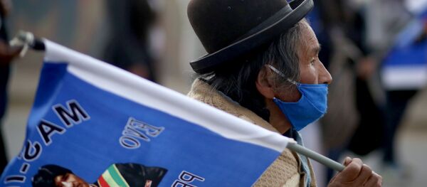 Un boliviano y la bandera con la imagen de Evo Morales - Sputnik Mundo