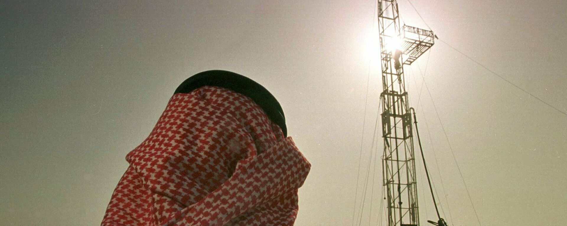 Un empleado de la compañía petrolera saudí observa el progreso de una plataforma situada en un yacimiento petrolero  - Sputnik Mundo, 1920, 19.12.2022