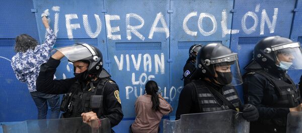Los manifestantes hacen un graffiti en una valla metálica que rodea la estatua de Cristobal Colón para su protección, CDMX - Sputnik Mundo