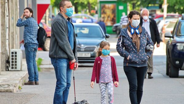 Una familia con mascarillas (imagen referencial) - Sputnik Mundo