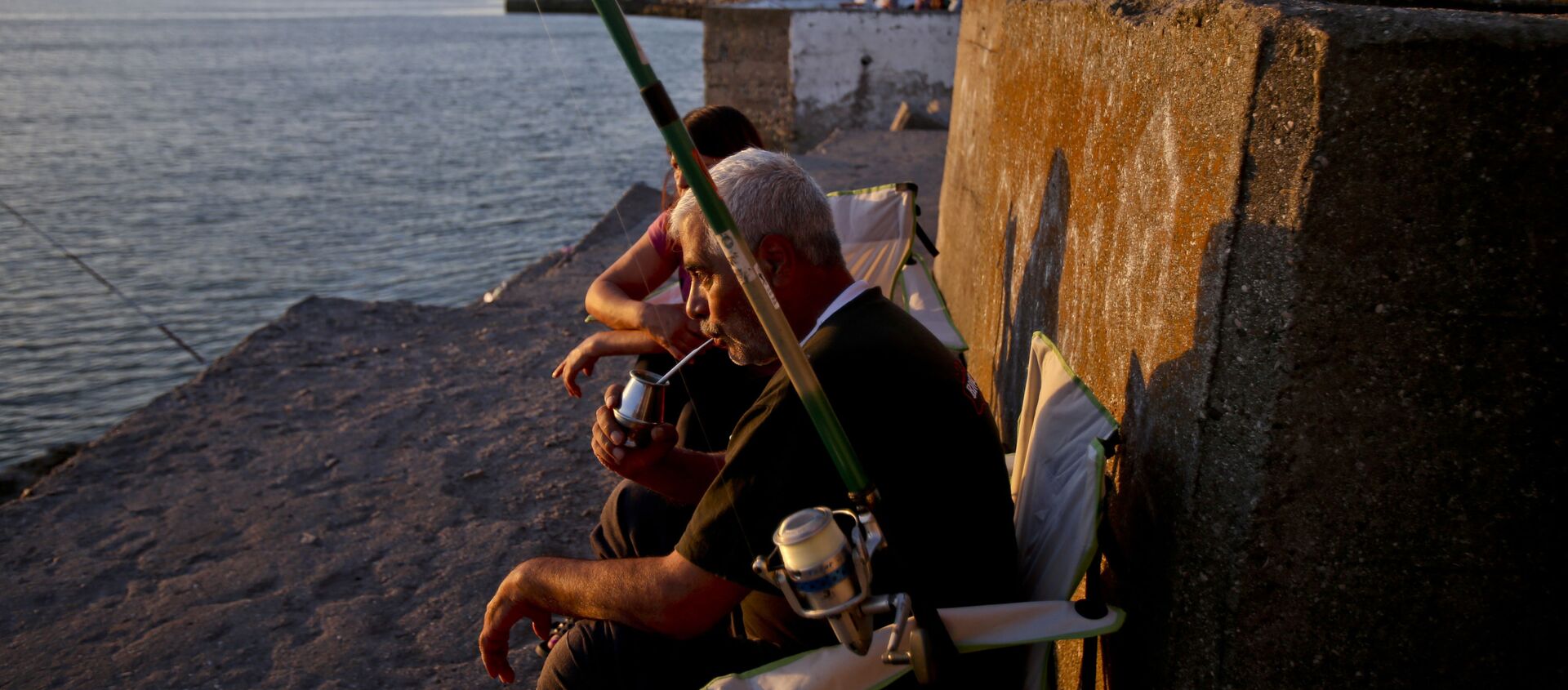 Un hombre toma mate mientras pesca en Mar del Plata, Argentina - Sputnik Mundo, 1920, 19.10.2020