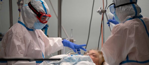 Los médicos atienden a un paciente con COVID-19 - Sputnik Mundo
