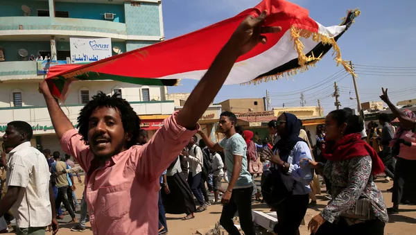 Un hombre con la bandera de Sudán - Sputnik Mundo