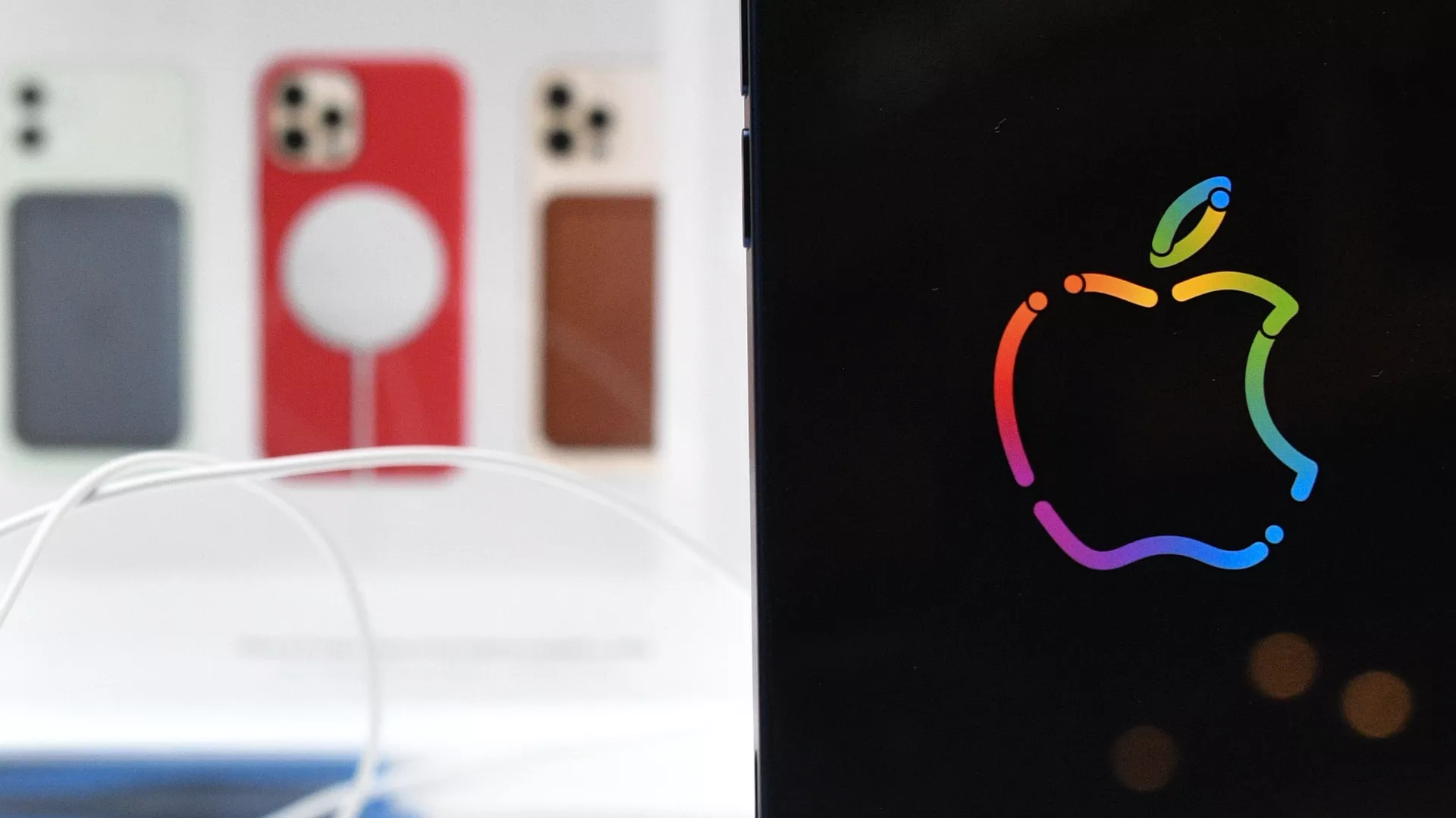 Logo de la compañía Apple con los iPhones en el fondo