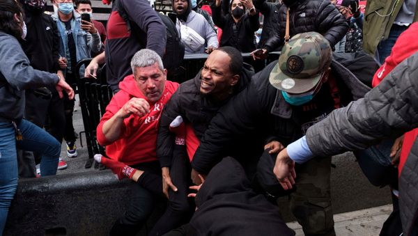 Un hombre protege a un partidario del presidente estadounidense Donald Trump de los manifestantes de la marcha anti-Trump después de los enfrentamientos en el distrito de Manhattan de la ciudad de Nueva York Un hombre protege a un partidario del presidente estadounidense Donald Trump de los manifestantes de la marcha anti-Trump después de los enfrentamientos en el distrito de Manhattan de la ciudad de Nueva York - Sputnik Mundo