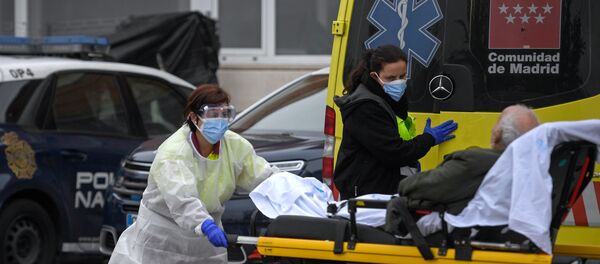 Sanitarias bajando a un paciente de un ambulancia en Madrid - Sputnik Mundo