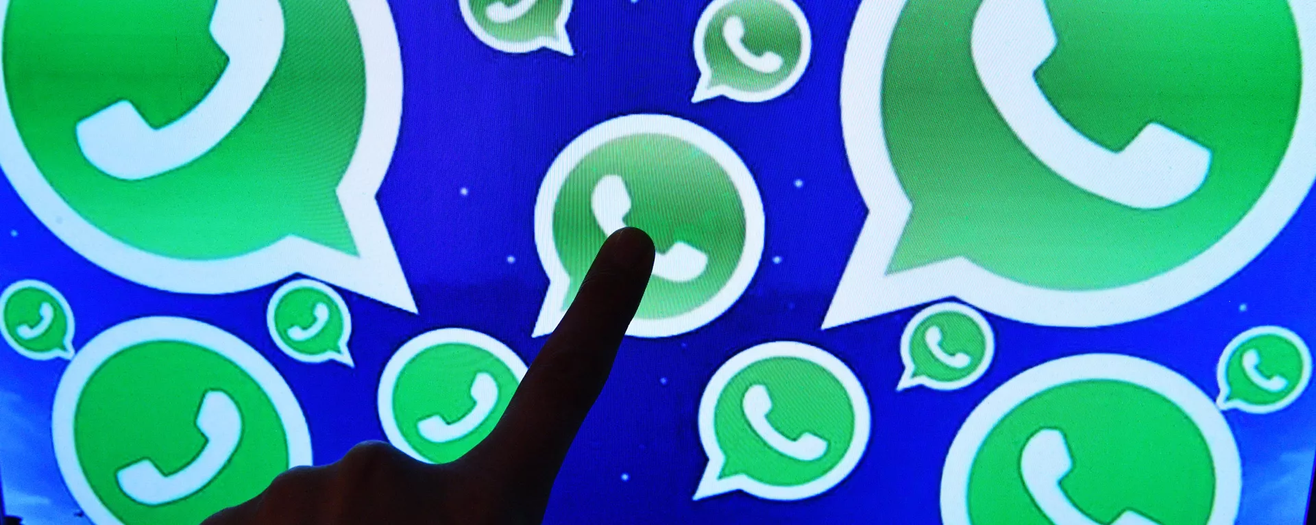Una persona toca una pantalla en la que se ven diversos logotipos de la aplicación WhatsApp Una persona toca una pantalla en la que se ven diversos logotipos de la aplicación WhatsApp - Sputnik Mundo, 1920, 08.10.2021