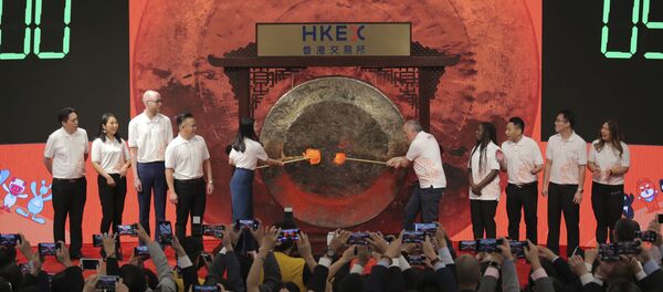 Miembros de la empresa Alibaba golpean el gong durante su salida a la bolsa de Hong Kong  - Sputnik Mundo